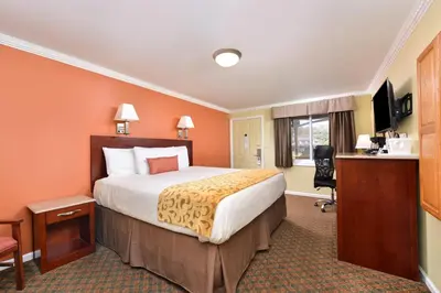 a hotel room with a bed and a desk at Cheshire Welcome Inn in Cheshire