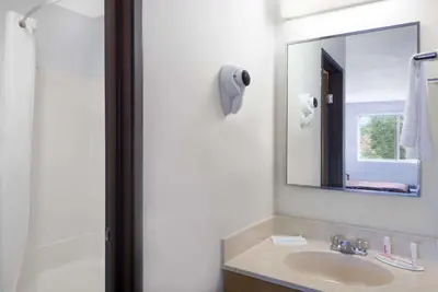 a bathroom with a sink and a mirror at Super 8 by Wyndham Kingston in Kingston