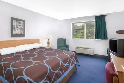 a hotel room with a bed and a television at Super 8 by Wyndham Kingston in Kingston