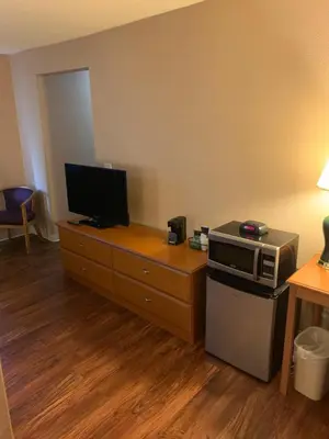 a room with a microwave and a television on a table at Super 8 by Wyndham Kingston in Kingston