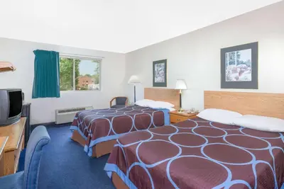 a hotel room with two beds and a flat screen tv at Super 8 by Wyndham Kingston in Kingston
