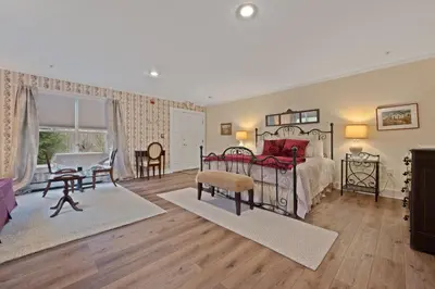 a bedroom with a bed and a table and chairs at Brook Farm Inn in Lenox