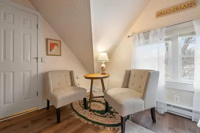 two chairs and a table in a room with a window at Brook Farm Inn in Lenox