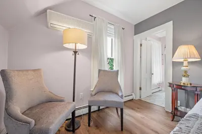 a living room with two chairs and a lamp at Brook Farm Inn in Lenox