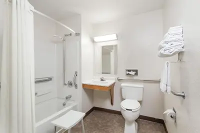 a white bathroom with a toilet and a sink at Super 8 by Wyndham Sidney NY in Sidney