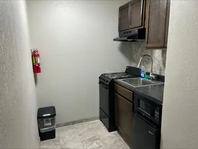 a small kitchen with a stove and a sink at Red Roof Inn Norwich in Norwich