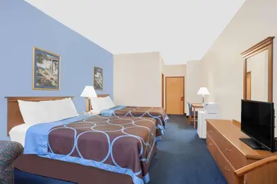 a hotel room with two beds and a flat screen tv at Super 8 by Wyndham Cobleskill NY in Cobleskill