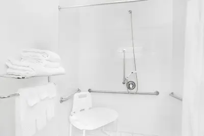 a white bathroom with a toilet and a shower at Super 8 by Wyndham Cobleskill NY in Cobleskill