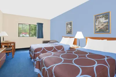 a hotel room with two beds and a desk at Super 8 by Wyndham Cobleskill NY in Cobleskill