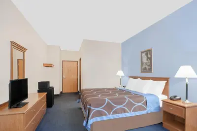 a hotel room with a bed and a flat screen tv at Super 8 by Wyndham Cobleskill NY in Cobleskill