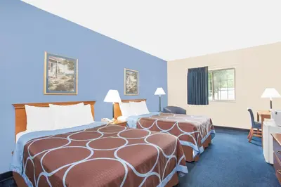 a hotel room with two beds and a desk at Super 8 by Wyndham Cobleskill NY in Cobleskill