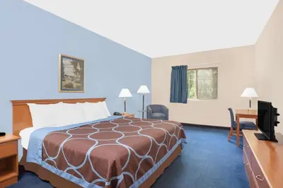 a hotel room with a bed and a desk and a television at Super 8 by Wyndham Cobleskill NY in Cobleskill