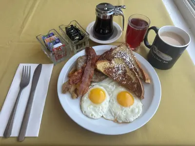 a plate of eggs bacon and toast on a table at Gray Ghost Inn in West Dover