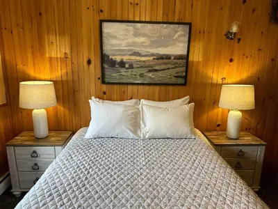 a bedroom with a bed with two lamps and a painting at Gray Ghost Inn in West Dover