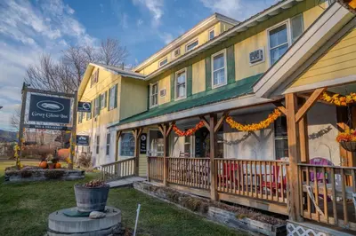 a large yellow building with a porch at Gray Ghost Inn in West Dover