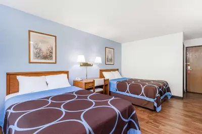 a hotel room with two beds and a desk at Super 8 by Wyndham Norwich in Norwich