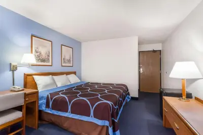a hotel room with a bed and a desk at Super 8 by Wyndham Norwich in Norwich