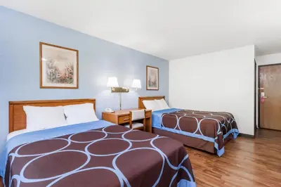 a hotel room with two beds and a desk at Super 8 by Wyndham Norwich in Norwich