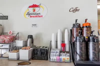 a coffee shop with a counter with a sign on the wall at Super 8 by Wyndham Norwich in Norwich