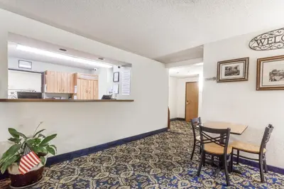 an empty waiting room with a table and chairs at Super 8 by Wyndham Norwich in Norwich