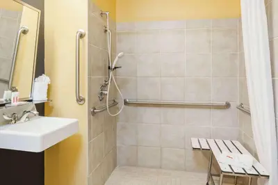 a bathroom with a sink and a shower at Microtel Inn & Suites in Dickson City