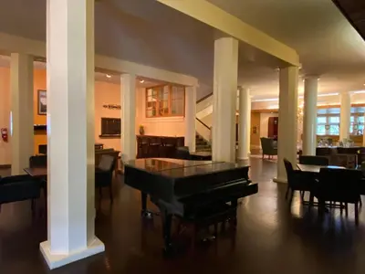 a living room with a piano and tables and chairs at Shawnee Inn and Golf Resort in East Stroudsburg