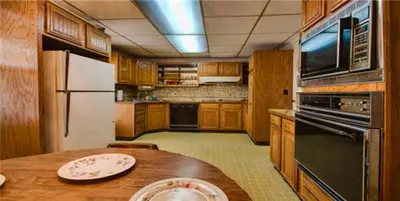 a kitchen with a wooden table and a kitchen with a refrigerator at Suites on Main in Margaretville