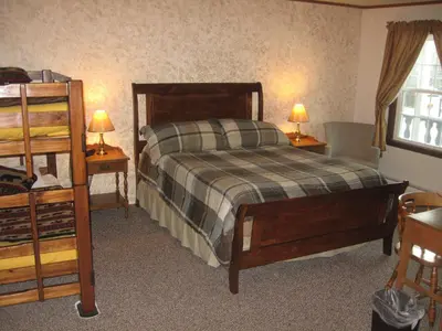 a bedroom with a bed and two tables and two lamps at Big Bears Lodge in West Dover