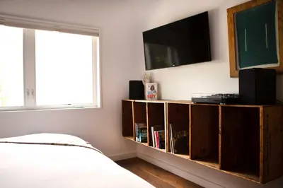 a bedroom with a book shelf with a flat screen tv at Woodstock Way Hotel in Woodstock