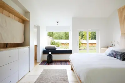 a white bedroom with a large bed and a window at Tourists in North Adams