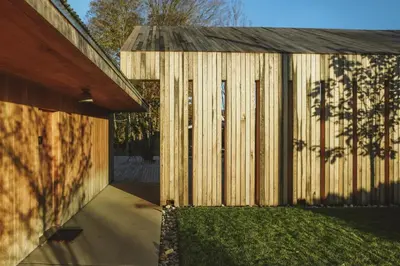 a wooden building with a wooden wall next to a yard at Tourists in North Adams