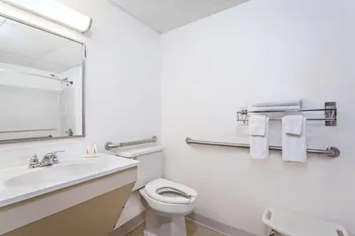 a bathroom with a sink and a toilet and a mirror at Super 8 by Wyndham Oneonta/Cooperstown in Oneonta