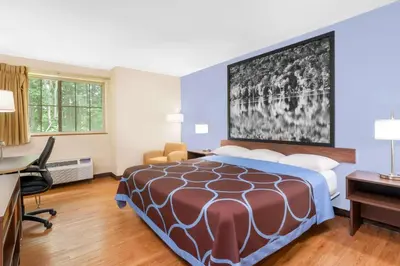 a hotel room with a bed and a desk at Super 8 by Wyndham Oneonta/Cooperstown in Oneonta