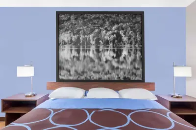 a bedroom with a bed with two lamps and a painting at Super 8 by Wyndham Oneonta/Cooperstown in Oneonta