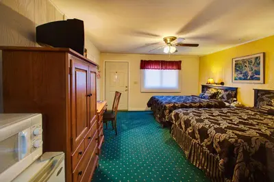 a hotel room with two beds and a desk at Margaretville Motel in Margaretville