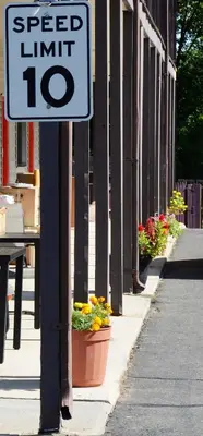 a speed limit sign on the side of a building with flowers at Enfield Inn in Enfield