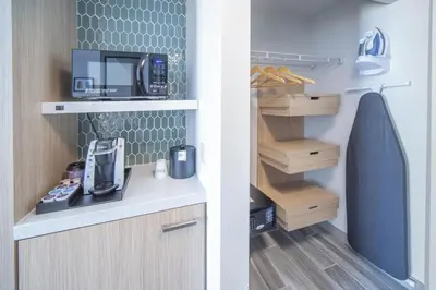 two pictures of a kitchen with a microwave at Hilton Garden Inn Clifton Park in Clifton Park