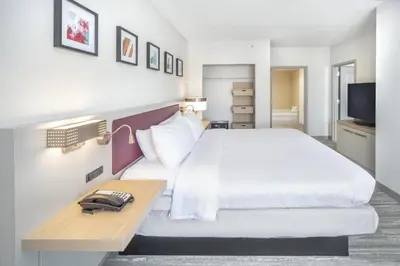 a hotel room with a bed with a phone on a table at Hilton Garden Inn Clifton Park in Clifton Park