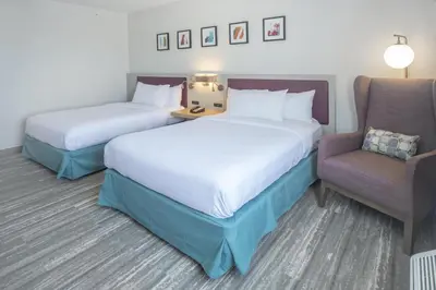 a hotel room with two beds and a chair at Hilton Garden Inn Clifton Park in Clifton Park