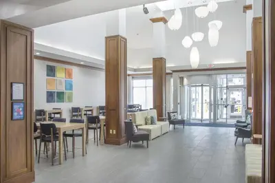 a lobby with a waiting room with a table and chairs at Hilton Garden Inn Clifton Park in Clifton Park