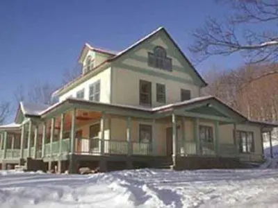a large house with snow in front of it at Breezy Hill Inn in Fleischmanns