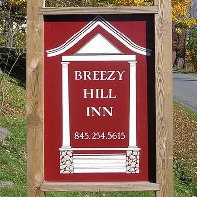 a sign for a brewers hill inn on a street at Breezy Hill Inn in Fleischmanns