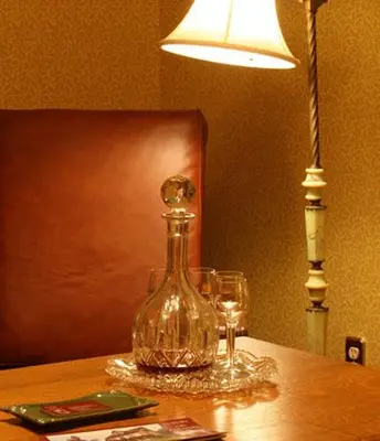 a glass bottle sitting on a table with two glasses at Breezy Hill Inn in Fleischmanns