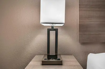 a lamp sitting on a table next to a wall at Red Roof Inn Queensbury in Queensbury