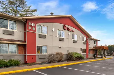a red and white building with a restaurant at Red Roof Inn Queensbury in Queensbury