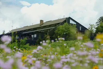 a building with a field of flowers in front of it at Scribner's Catskill Lodge, a Member of Design Hotels in Hunter