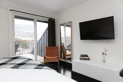 a bedroom with a flat screen tv on the wall at Scribner's Catskill Lodge, a Member of Design Hotels in Hunter