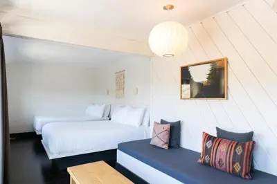 a bedroom with two beds and a bench in a room at Scribner's Catskill Lodge, a Member of Design Hotels in Hunter