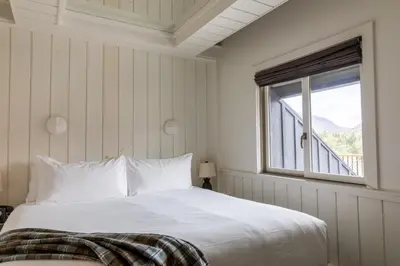 a bedroom with a white bed and a window at Scribner's Catskill Lodge, a Member of Design Hotels in Hunter