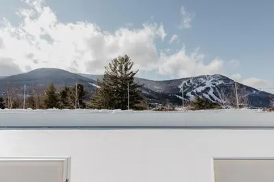 a tennis court with a snowy mountain in the background at Scribner's Catskill Lodge, a Member of Design Hotels in Hunter
